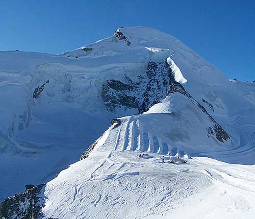 Allalinhorn 4.027 m – uprostřed severní hřeben, vlevo SV stěna a Hohlaubgrat, vpravo SZ stěna a za ní Feejoch 3.826 m