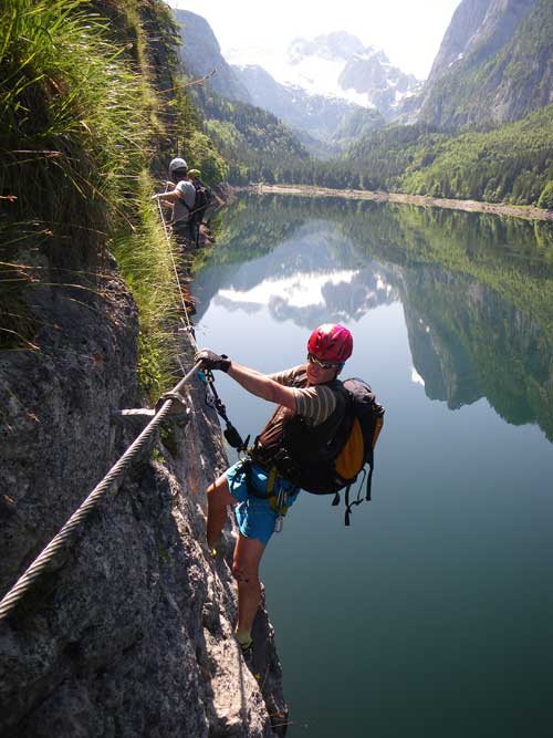 Michal nastupuje lehce převislým traverzem s krásným výhledem na Dachstein